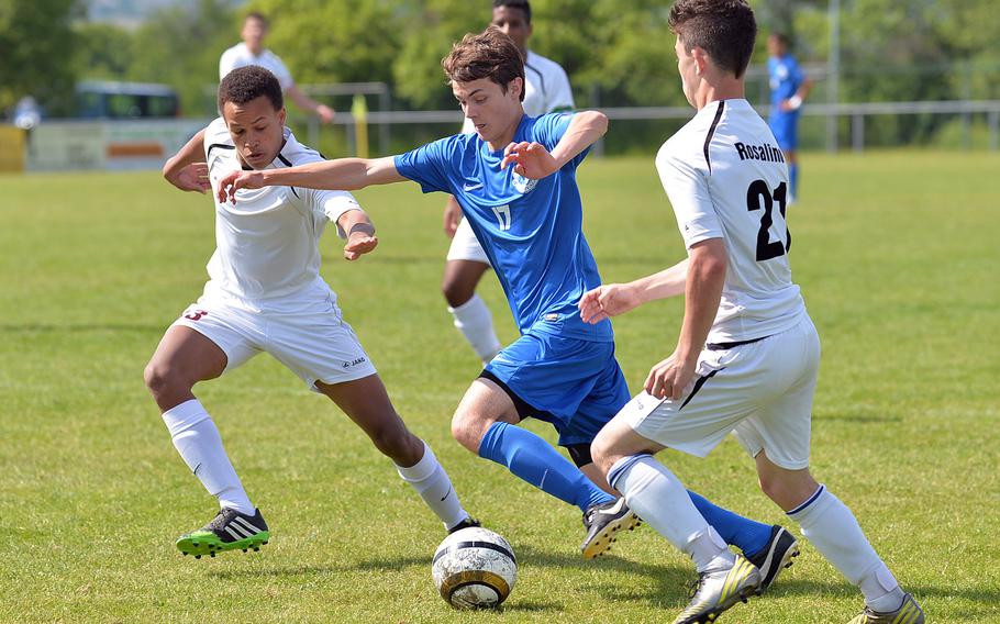 Ramstein's Bryant Allred splits the Vilseck defense of Femi Whitehead, left, and William Rosalino on his way to scoring a goal in the Royals' 4-0 win in a Division I match at the DODDS-Europe soccer championships at Reichenbach, Germany, Tuesday, May 20, 2014.