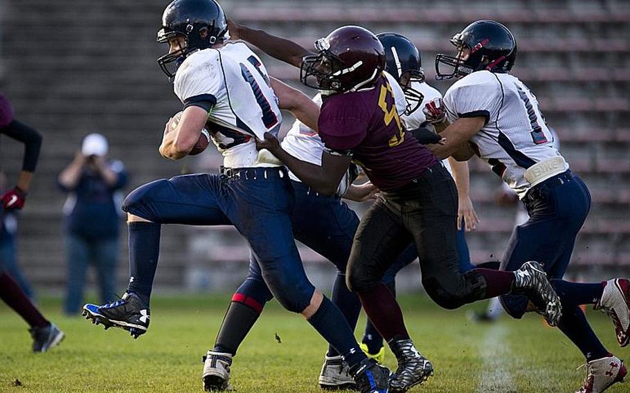 Bitburg's John Blake tries to break a tackle by Baumholder's Anthony Amos in Baumholder, Germany, Sept. 25, 2015. Blake, Amos and hundreds of other players in DODDS-Europe schools are told that their games are not win-at-all-costs. How they carry themselves is as important as how far they carry the ball.
