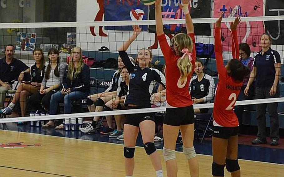 Black Forest Academy's Kaitlyn Richter hits the ball by two Aviano defenders October 24, 2015 during a match at Aviano Air Base, Italy.