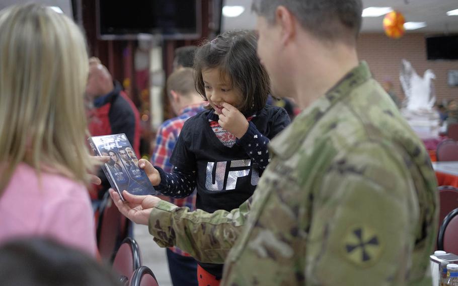 A young Ultimate Fighting Championship fan shows her parents one of the gifts she received from UFC fighters during Thanksgiving dinner on Thursday, Nov. 26, 2015, at U.S. Army Garrison Yongsan in Seoul, South Korea.