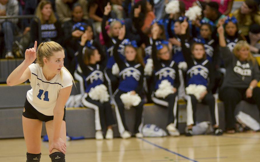 Along with the Admiral cheerleaders in the background, Rota's Janae Curtice signals that her team is one point away from winning the DODDS Division II volleyball championship match against Bitburg High School, Saturday, Nov. 7, 2015. Rota won the match in three sets and Curtice was named the tournament's most valuable player.