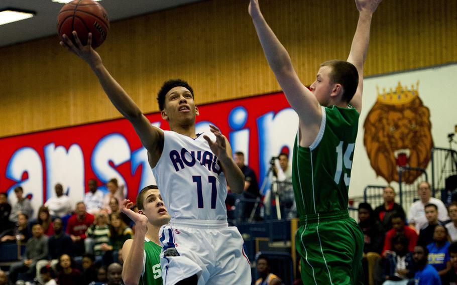 Ramstein Royal D'Angelo Griggs goes up for a shot as SHAPE Spartan Matt Hoover attempts a block during the DODDS-Europe holiday tournament at Ramstein Air Base, Germany, on Monday, Dec. 21, 2015.