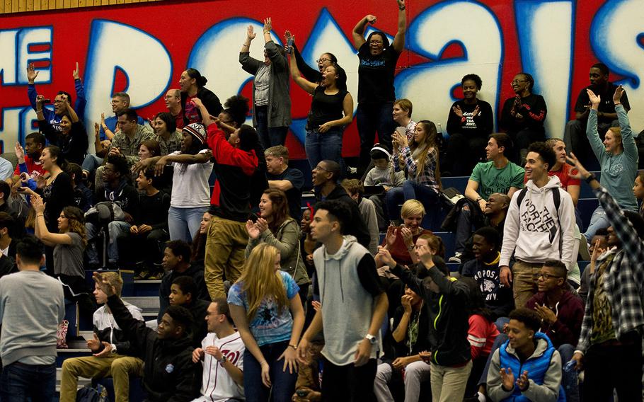 Fans cheer after the Ramstein Royals beat the buzzer with a three-point shot during the DODDS-Europe holiday tournament at Ramstein Air Base, Germany, on Monday, Dec. 21, 2015. The Royals beat the SHAPE Spartans 44-21, and won the tournament.
