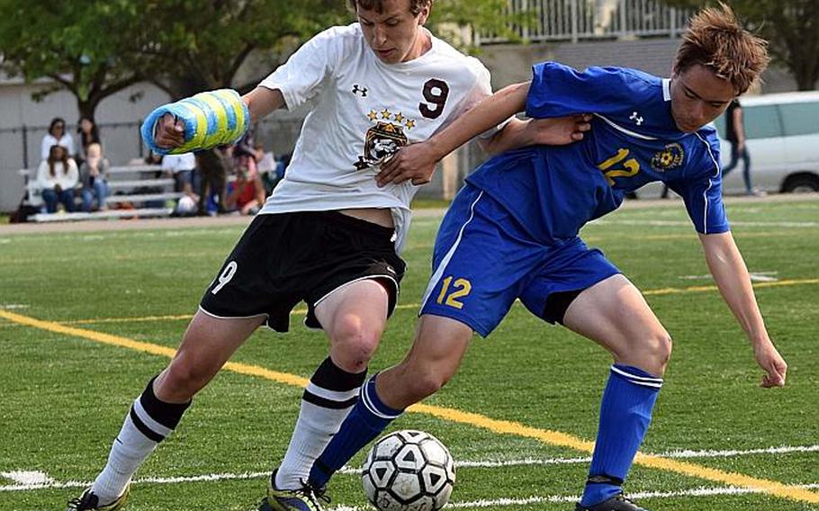 Matthew C. Perry's Aidan Lewis, adorned with a bubble-wrapped cast on his fractured right wrist, battles for the ball against Yokota's Keanu McElroy.