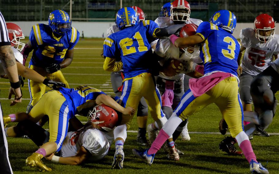 Kinnick quarterback Kacey Walker trucks through two Yokota defenders on a quarterback draw in the end zone during the Devils' 35-0 victory over the host Panthers Friday, Oct. 7, 2016, at Yokota Air Base, Japan. Walker accounted for three scores with two rushing touchdowns and one passing.