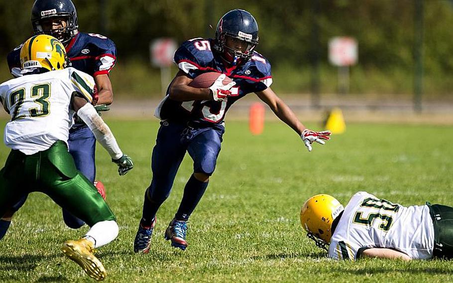 Bitburg's Jimmie Montgomery runs through a gap in the SHAPE defense in Bitburg, Germany, on Saturday, Sept. 17, 2016. Bitburg won 44-3.