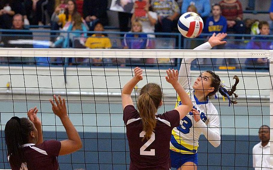 Sigonella's Korley Jones goes high to knock the ball over the net against Baumholder's Tytianna Martinez, left, and Annabel Brinkmeyer in Sigonella's 25-11,25-21, 2516 win in the Division III title game at the DODEA-Europe volleyball championships in Kaiserslautern, Germany, Saturday, Nov. 5, 2016.