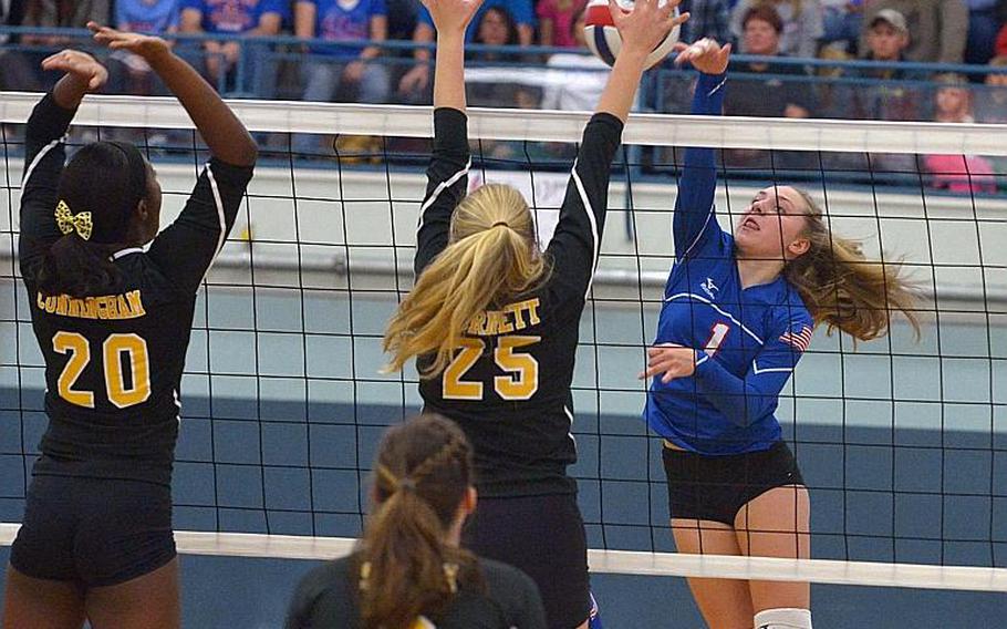 Ramstein's Amelia Jones hits the ball against the Stuttgart defense of Medeau Cunningham, left, and Peyton Burnett at the DODEA-Europe volleyball championships in Kaiserslautern, Germany, Saturday, Nov. 5, 2016. The Panthers defeated the Royals 25-18, 25-19, 25-23.