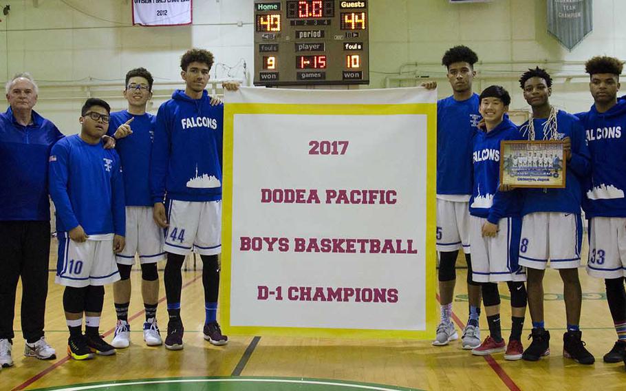Seoul American players and coaches gather round the banner following their 49-44 win Thursday over Kadena in the Far East Boys Division I Tournament final.