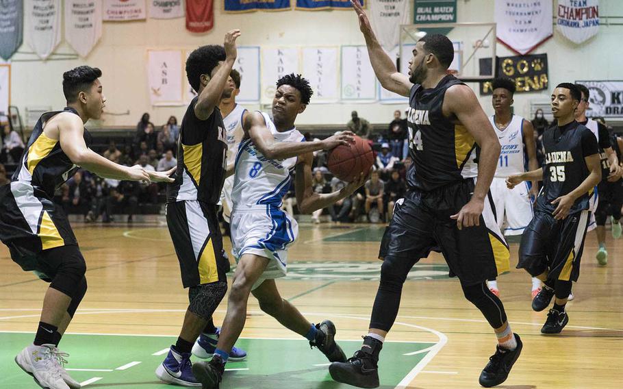 Seoul American's Willie Grandison tries to drive through Kadena defensive traffic during Thursday's Far East Boys Division I Tournament final. The Falcons won 49-44.