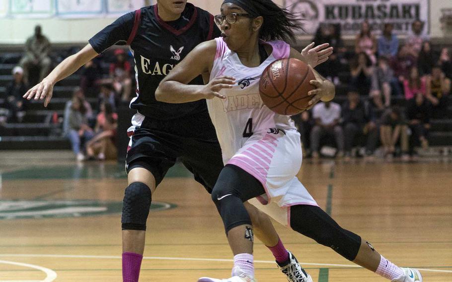 Kadena's Rhamsey Wyche drives against American School of Bangkok defender Shanique Lucas during Thursday's Far East Girls Division I Tournament final. The Eagles dethroned the Panthers 52-31.