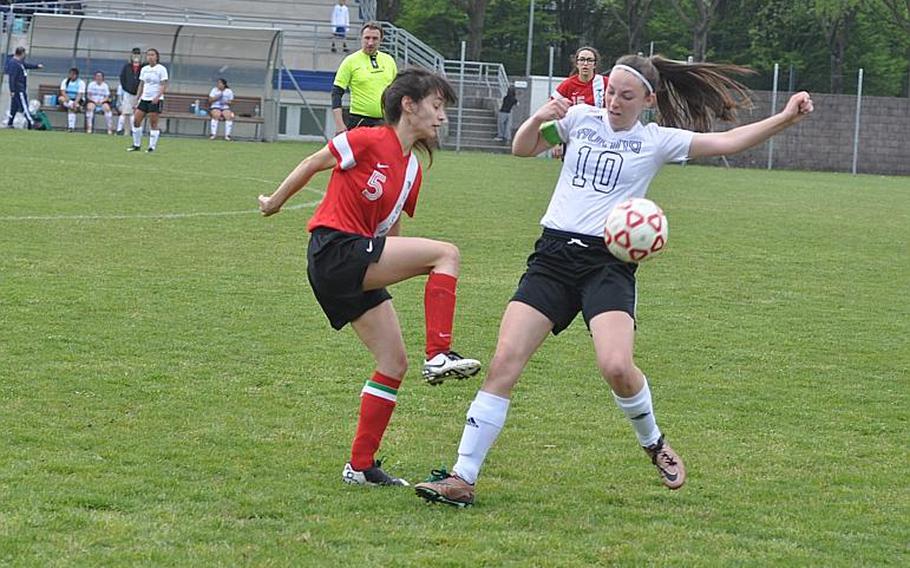 American Overseas School of Rome's Anne-Constance Blanchette tries to kick the ball past Aviano's Kaila Lusson in the Saints' 4-3 victory Saturday.