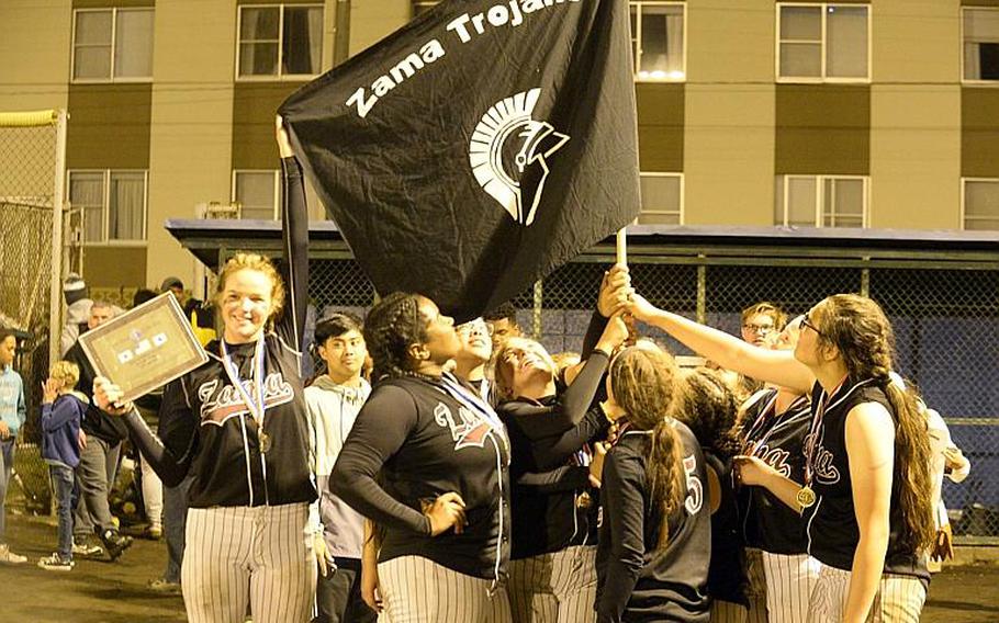 Zama players gather round a flag emblematic of their school after beating Yokota 13-3 in the third of three Far East Division II Softball Tournament final games on Wednesday.

DAVE ORNAUER/STARS AND STRIPES