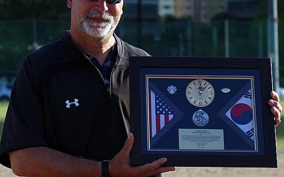 American School In Japan coach John Seevers displays a farewell gift given to him after his Mustangs beat Kadena 5-4 for their fourth straight Far East Division I Baseball Tournament title. Seevers is retiring after 40 years at ASIJ.

WESTON GRAVES/SPECIAL TO STRIPES