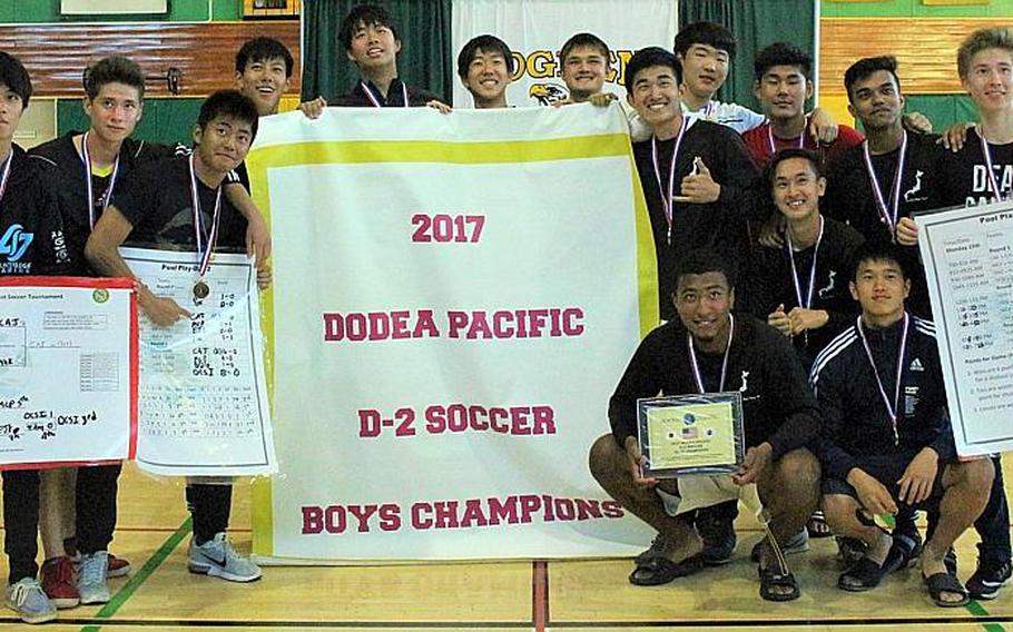 Christian Academy Japan players gather round the banner after Thursday's championship game in the Far East Boys Division II Soccer Tournament, won by the Knights 7-0 over Yokota.

CAITLIN BLOUNT/SPECIAL TO STRIPES