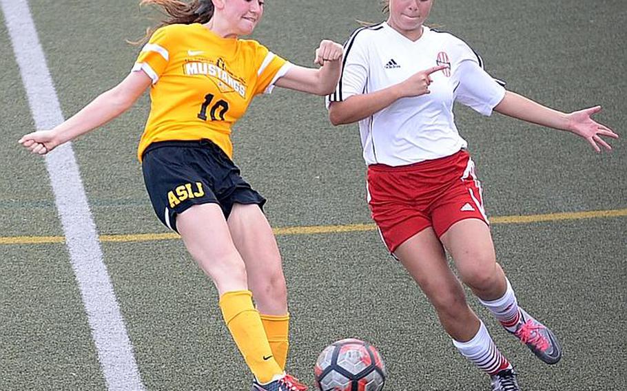 American School In Japan's Rikako Kent boots the ball past Nile C. Kinnick's Hannah Quejada during Thursday's Far East Girls Division I Soccer Tournament final, won by the host Red Devils 3-0.

DAVE ORNAUER/STARS AND STRIPES