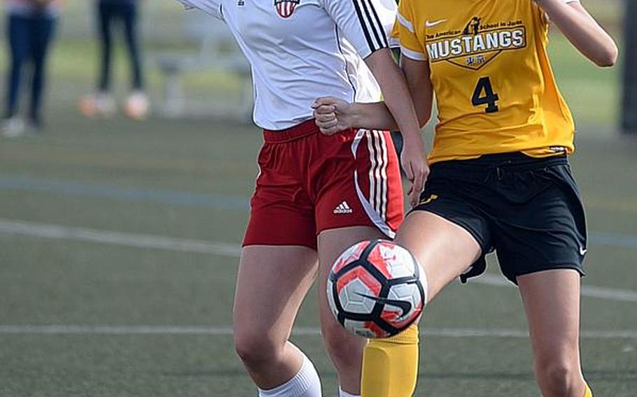 Nile C. Kinnick's Hope McDonald and American School In Japan's Isabelle Franz battle for the ball during Thursday's Far East Girls Division I Soccer Tournament final, won by the host Red Devils 3-0.

DAVE ORNAUER/STARS AND STRIPES