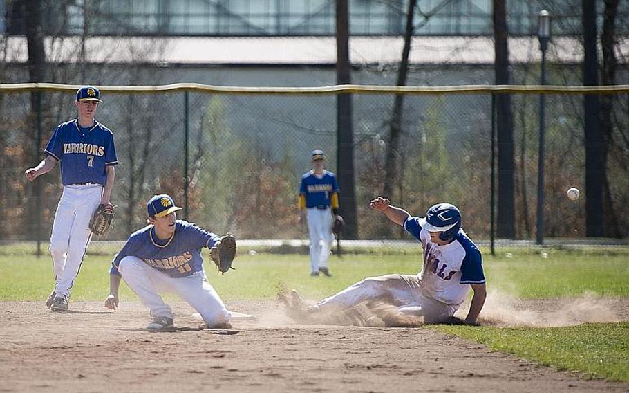 Ramstein's Kyle Glenn slides into second base as Wiesbaden's Damian Pinion, center, waits for the throw and Finn Swafford watches the play at Ramstein Air Base, Germany, on Thursday, March 30, 2017.
