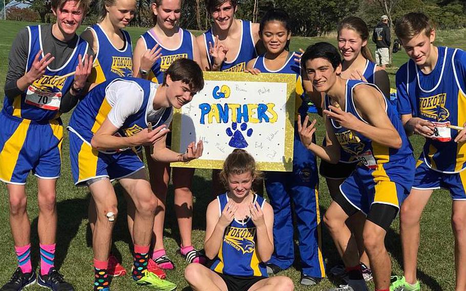 Yokota's cross country team celebrates its third straight Far East Division II boys team title and second straight overall school banner following the Far East meet.