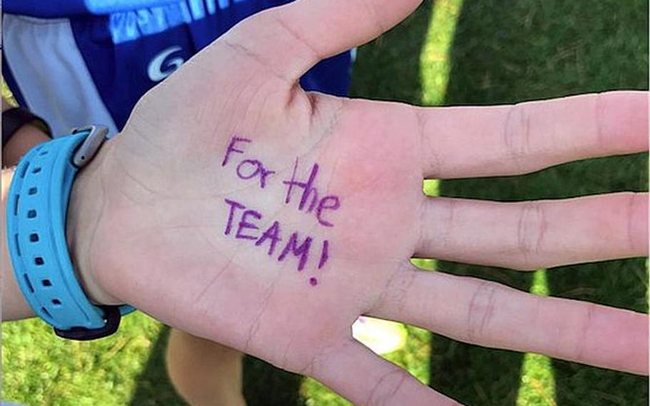 Seoul American runners wrote on their left hands "For The Team!" prior to Thursday's Far East cross country team relay. Seoul American's Tucker Chase and Chloe Byrd crossed the finish line first.