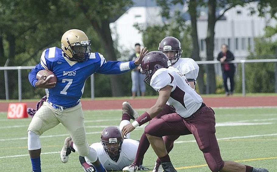 Wiesbaden junior quarterback Josh Blake holds off a Vilseck defender in their season-opening matchup Saturday, Sept. 9, 2017 in Wiesbaden, Germany. Blake threw for two touchdowns and ran for another as the Warriors defeated the Falcons 38-0.