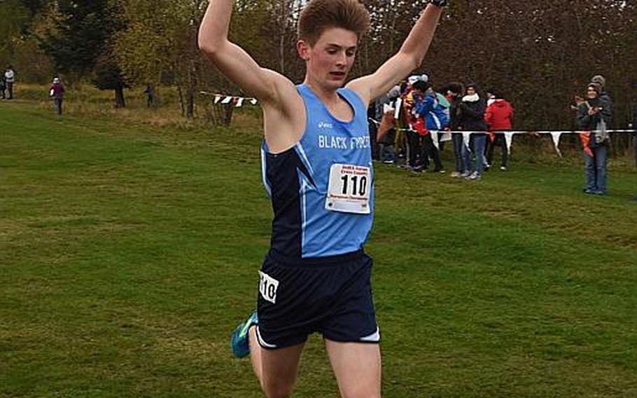 Mac Roberts, a junior from Black Forest Academy, raises his arms in triumph after crossing the finish line first on Saturday, Oct. 28, 2017, at the DODEA European cross country championships in Baumholder, Germany. Roberts ran 16:48.98 on the 5-kilometer course to win his first European title.