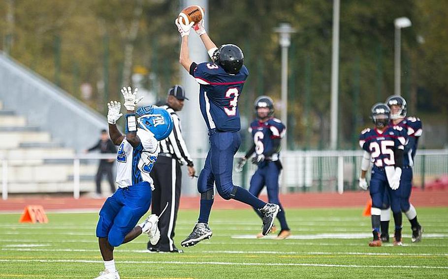 Spangdahlem's Kyros Bettelyoun, right, catches an interception over Rota's Cameron Wilson at Vogelweh, Germany, on Saturday, Nov. 4, 2017.