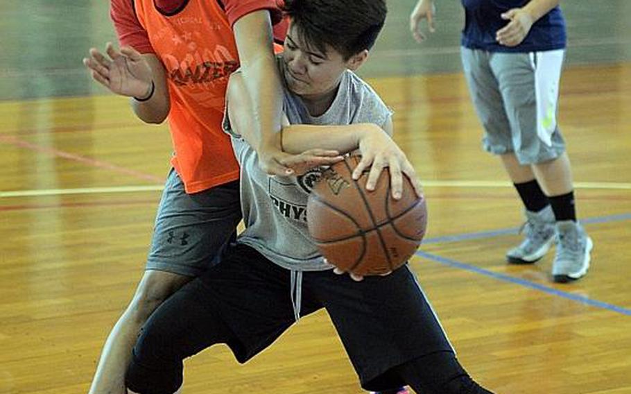 Kubasaki senior Nahla Wilson and sophomore Ari Gieseck battle for the ball during Dragons girls basketball practice.