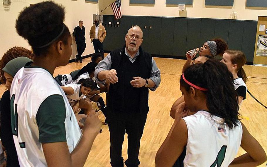 Daegu coach Victor Rivera goes over details with the girls basketball team in the huddle during a timeout.