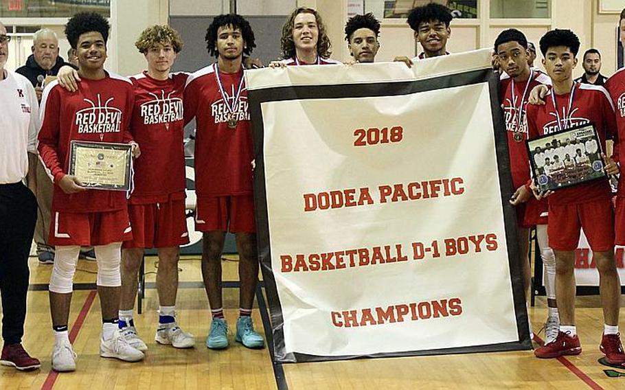 Nile C. Kinnick players display the banner emblematic of their school-first Far East Division I Basketball Tournament title.