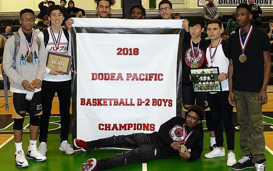 Humphreys Blackhawks players gather around the banner symbolic of their school-first Far East Boys Division II Basketball Tournament title.