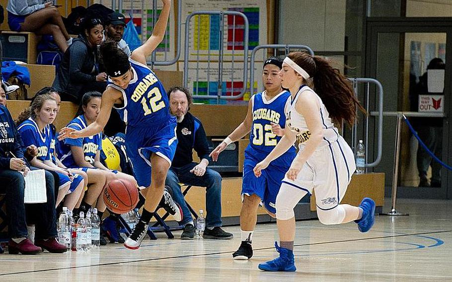 Ansbach's Shermaine Nesbitt jumps to keep the ball in play in front of Sigonella's Jessica Jacobs, right, and teammate Rona Denuna during the DODEA-Europe Division III championship in Wiesbaden, Germany, on Saturday, Feb. 24, 2018.