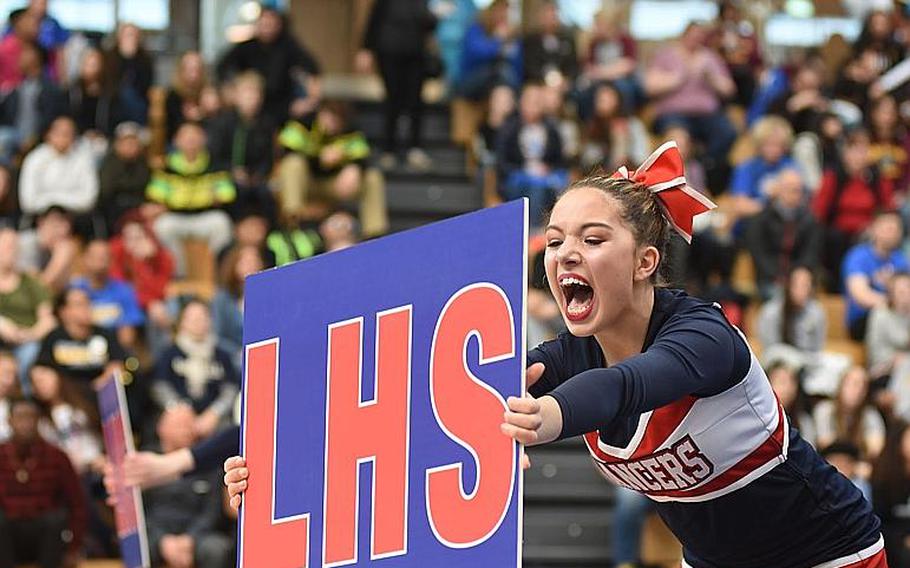Lakenheath senior Kennedy Johnson cheers while holding up a school sign during the DODEA-Europe cheer tournament on Saturday, Feb. 24, 2018, in Wiesbaden, Germany.