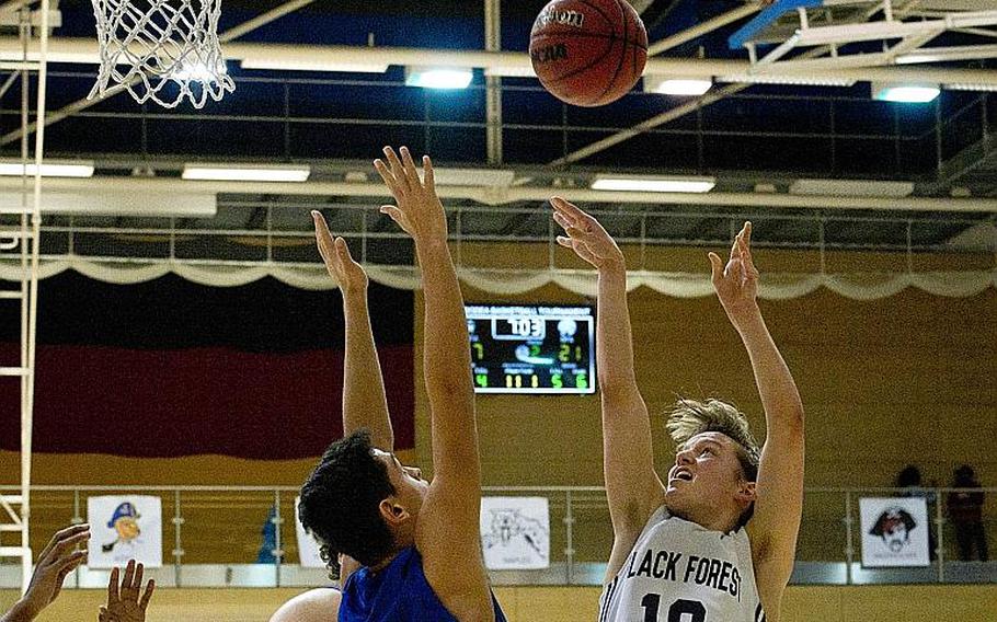 Black Forest Academy's Dillon Priest, right, shoots over Rota's Joseph Perches during the DODEA-Europe Division II championship in Wiesbaden, Germany, on Saturday, Feb. 24, 2018.