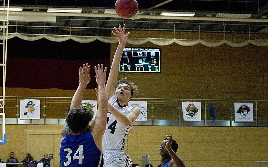 Black Forest Academy's Gabriel Kruse goes for a jumper over Rota's Andy Drake during the DODEA-Europe Division II championship in Wiesbaden, Germany, on Saturday, Feb. 24, 2018.