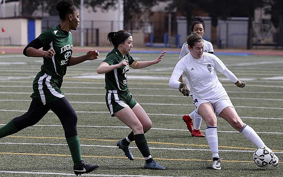 Junior Caleigh Garcia, dribbling against Robert D. Edgren's Christina Taylor and Abigail Gomez, is one of a handful of new key strikers for Yokota girls soccer.