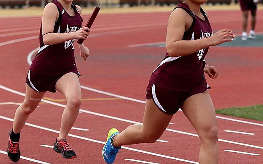 Relay runners Shion Rudolph and Skye Lebreton practice handoffs for first-year track and field program Matthew C. Perry.