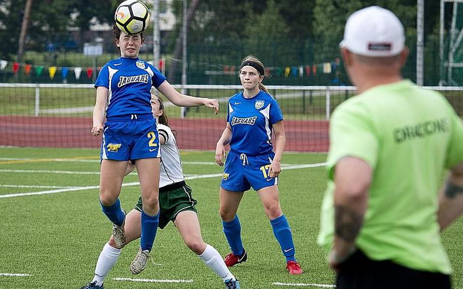 Sigonella's Cecelia Warren, left, heads the ball over Alconbury's Isabel Black as fellow Jaguar Emily Havard watches during the DODEA-Europe Division III soccer championship in Kaiserslautern, Germany, on Thursday, May 24, 2018.