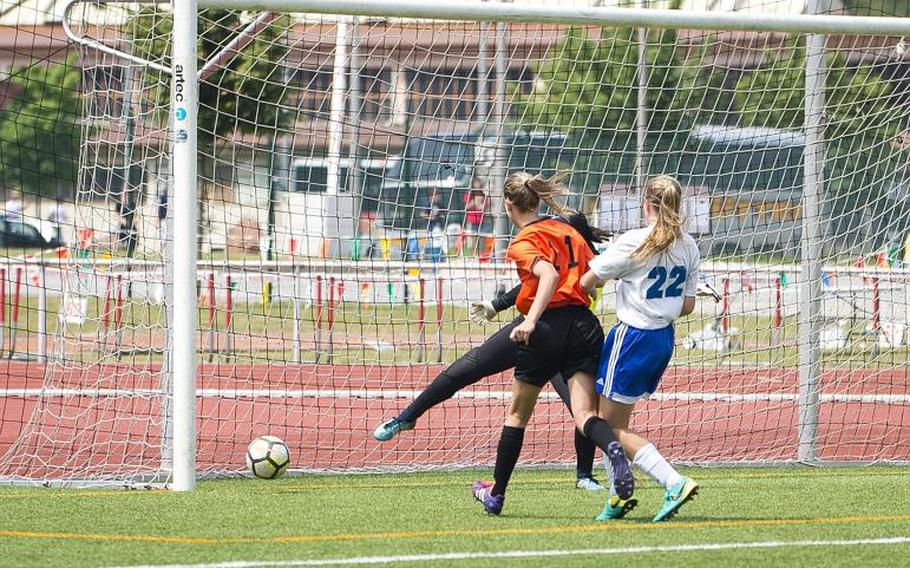 Spangdhalem's Ava Bohn gets a goal past both Rota's goalkeeper Arielle Reese and Samantha Miller, right, during the DODEA-Europe Division II soccer championship in Kaiserslautern, Germany, on Thursday, May 24, 2018.