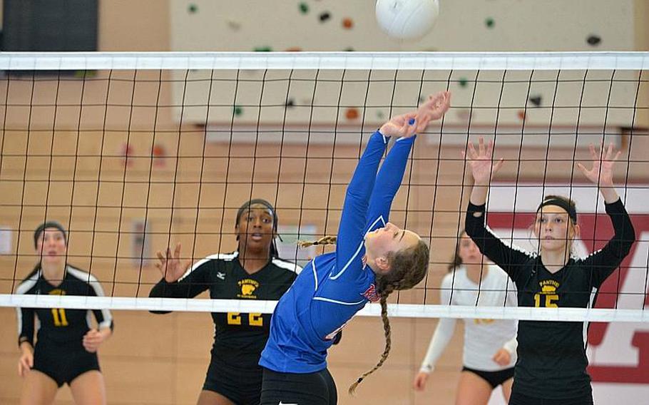 Ramstein's Sydney Gabriel sets the ball for a teammate as Stuttgart's Skye DaSilva Mathis, left, and Geneva Barriger wait to defend across the net. in the Division I final at the DODEA-Europe volleyball championships in Kaiserslautern, Germany. Stuttgart took the title with a 25-23, 25-18, 25-10 win over the Royals.