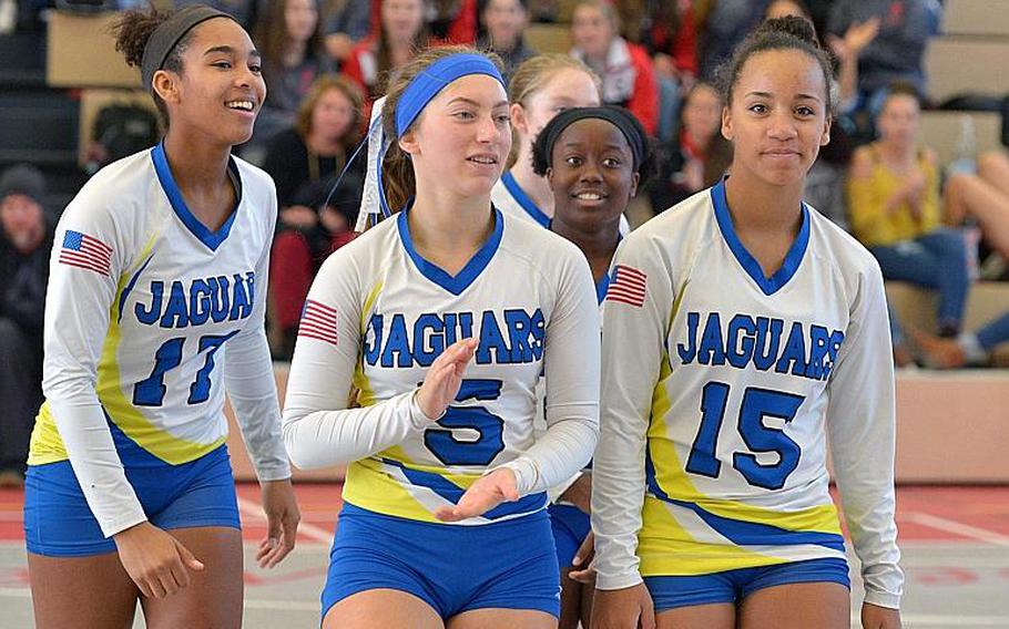 Sigonella's D'Anna Holland, Jessica Jacobs, Eliza Moore and Averi Chandler, from left, smile and clap as they walk off the court after defeating Brussels 25-14, 25-13, 23-25, 25-17 in the Division III title game at the DODEA-Euope volleyball championships in Kaiserslautern, Germany.