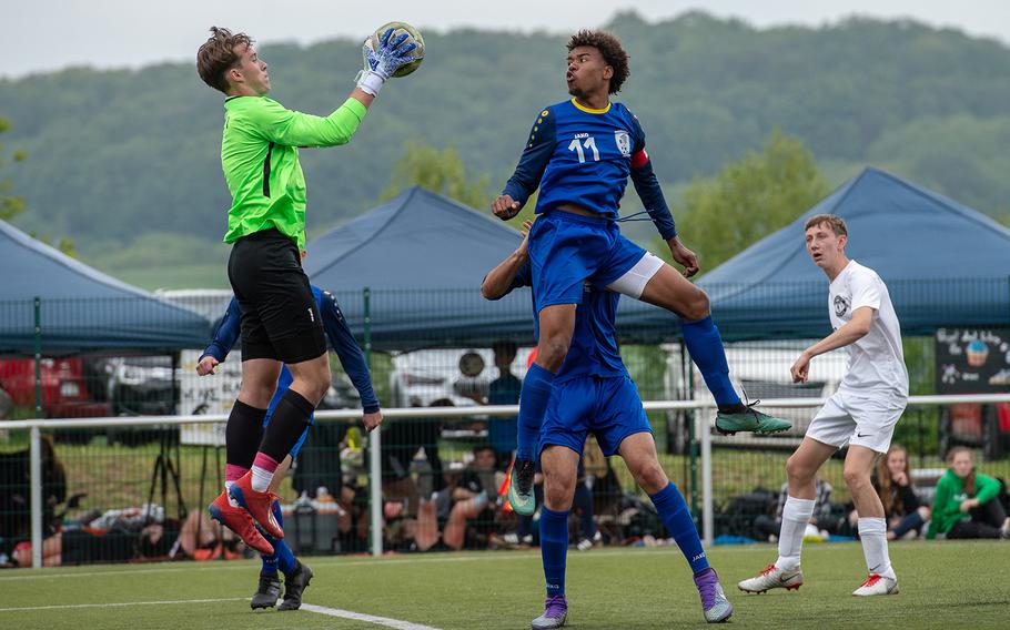 Ramstein goalkeeper Garrett Ericsson jumps to grab a free ball during a game against Wiesbaden on the first day of the DODEA-Europe soccer championships, Monday, May 20, 2019.