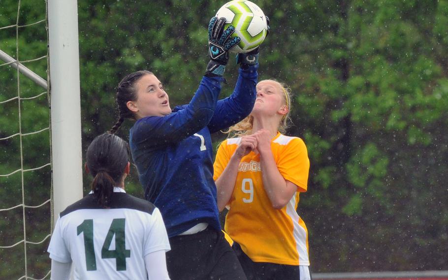 SHAPE keeper Mackenzie Barden pulls down a ball against Stuttgart's Mara Bartell in a Division I game in Reichenbach, Tuesday, May 21, 2019. Watching the action in Stuttgart's 4-0 win is SHAPE's Isabella Ortez.