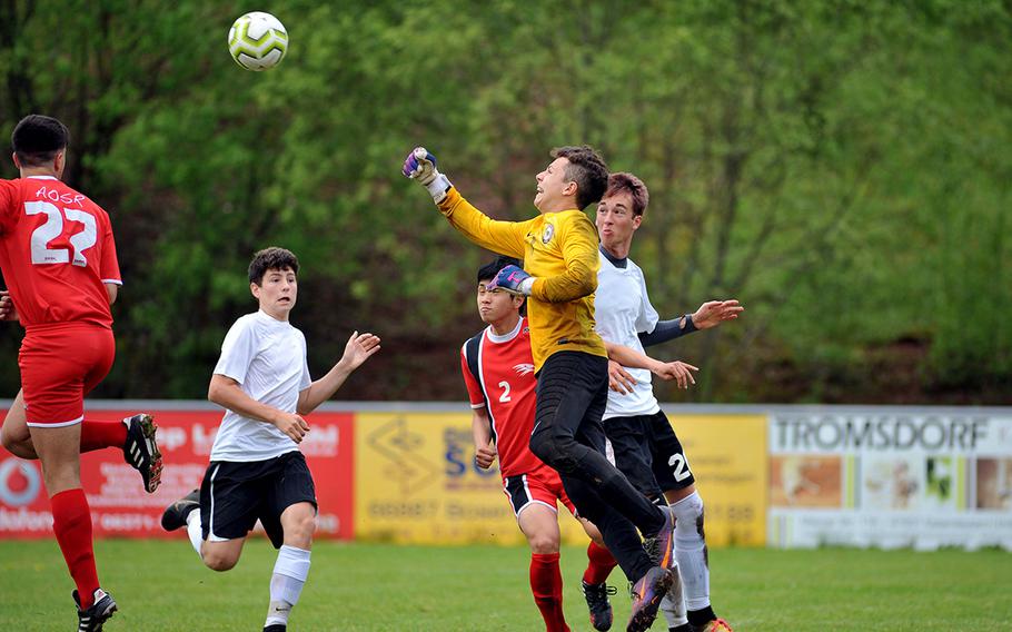 AOSR keeper Martin Jijena goes for the ball against AFNORTH's Preston Guza and Lisse Bohlen, right, as teammates Giuseppe Amara, left, and Seung Hyun Na watch the action in a Division II semifinal in Reichenbach, Wednesday, May 22, 2019. AOSR won the game 1-0 to advance to Thursday's final against Aviano.