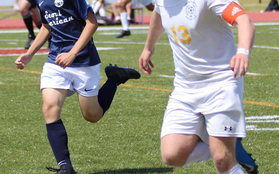 Seoul American' s David Lee and Yokota's Eli Newton chase the ball during Wednesday's Far East Boys Division II soccer tournament pool play. The Panthers won 2-0.