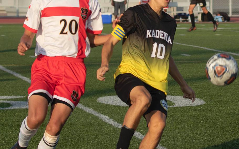 Kadena's Kian Smith and Kinnick's Daniel Burke chase the ball during Wednesday's Far East Boys Division I Soccer Tournament round-robin. The Red Devils won 3-2.