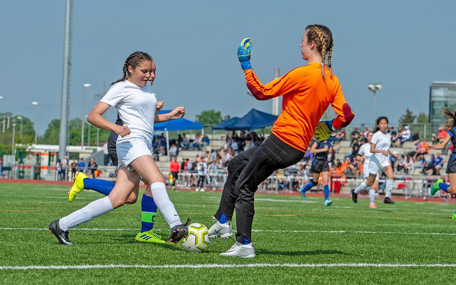 Spangdahlem's Chesney Tieyah drives to the goal as Hohenfels' goalie Kaetlyn Traux comes out to meet her during the girls Division III DODEA-Europe soccer championship game, Thursday, May 23, 2019. Spangdahlem won the game 4-2. 
