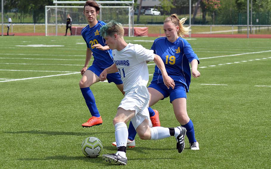 Sigonella's Naike Schauring gets past Ansbach defenders Eric Unger and Katherine McGrail in the boys Division III final at the DODEA-Europe soccer championships in Kaiserslautern, Germany, Thursday, May 23, 2019. Ansbach took the title with a 2-1 win with Schauring scoring his team's goal on a penalty kick. 