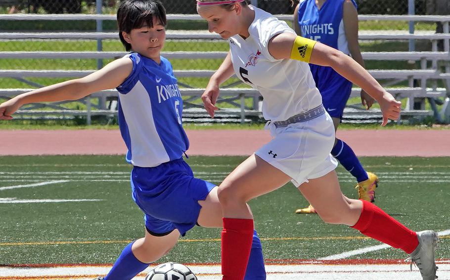 Christian Academy Japan's Miyuki Yamakawa and E.J. King's Gabi Shultz try to play the ball during Thursday's round-robin in the Far East Division II girls soccer tournament. The teams battled to a 1-1 draw.