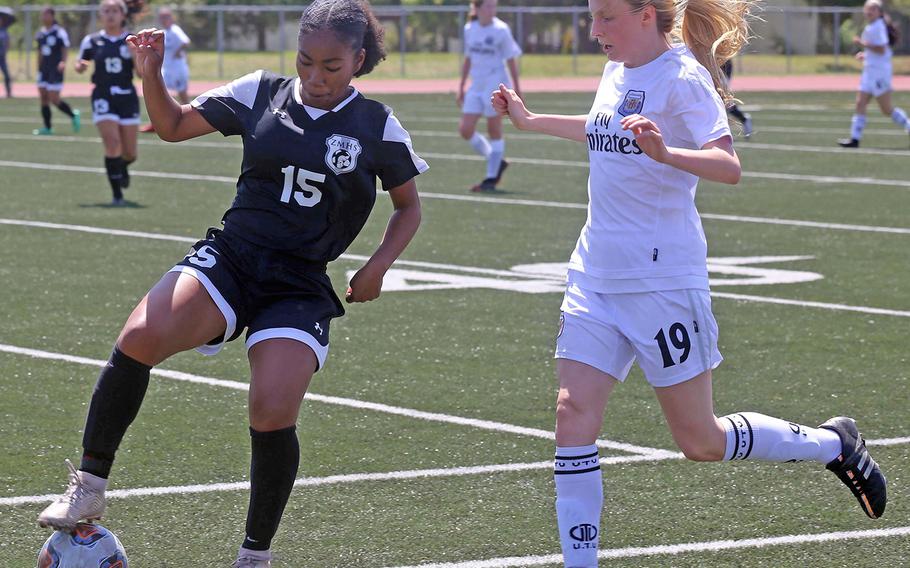Zama's Midori Robinson and Osan's Davinia Wengert battle for the ball during Thursday's round robin in the Far East Division II girls soccer tournament. The Trojans won 7-0.